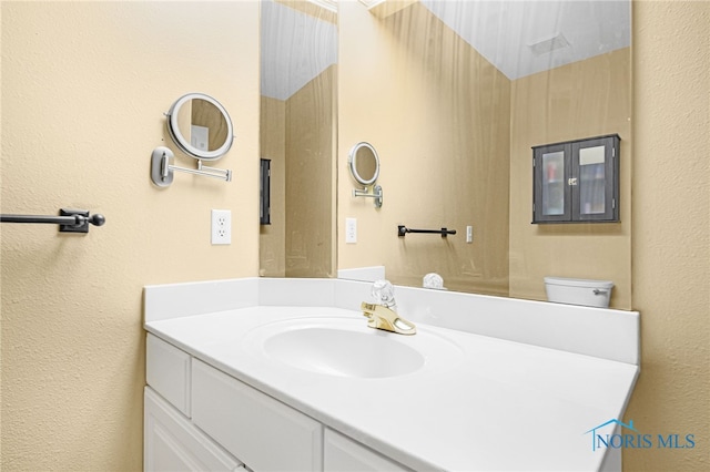 bathroom featuring a textured wall and vanity