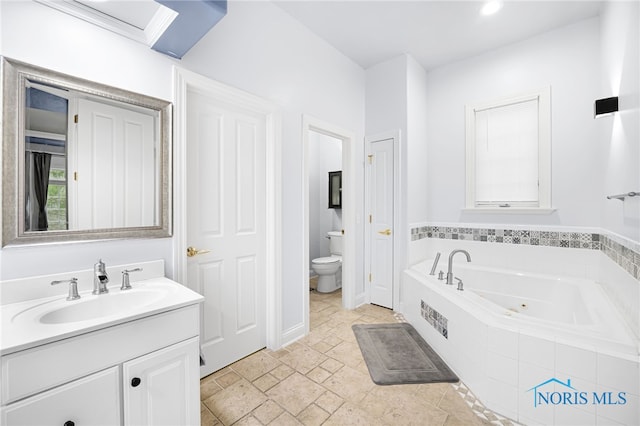 bathroom featuring a tub with jets, toilet, vanity, and stone finish flooring