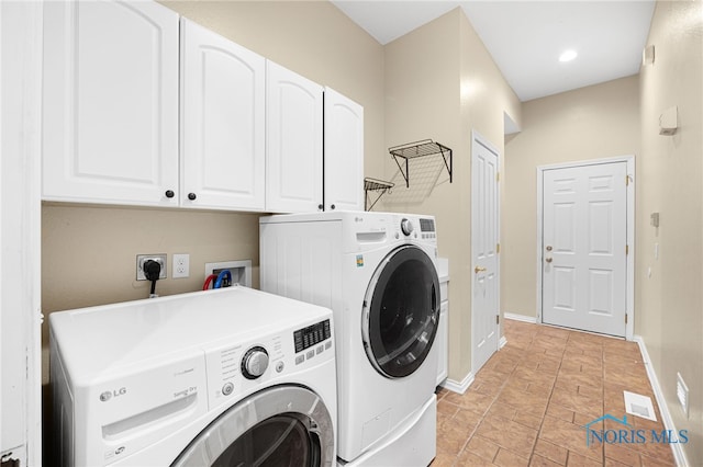 clothes washing area with independent washer and dryer, visible vents, cabinet space, and baseboards