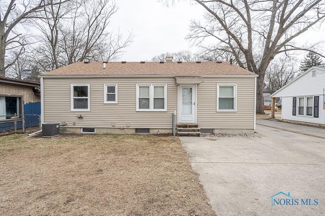 bungalow-style house featuring cooling unit, entry steps, and roof with shingles