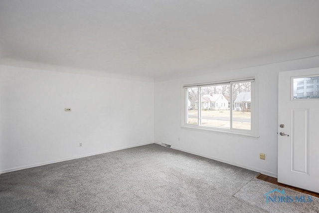 spare room featuring carpet flooring, visible vents, and baseboards