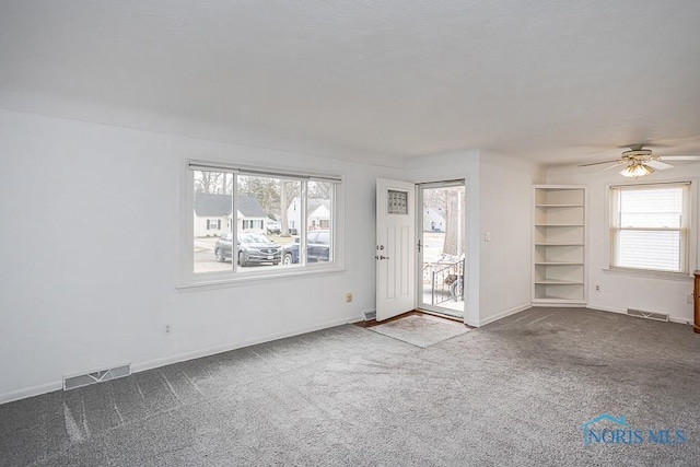 unfurnished room with baseboards, visible vents, and carpet floors