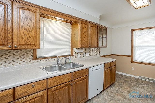 kitchen featuring visible vents, a sink, decorative backsplash, light countertops, and dishwasher