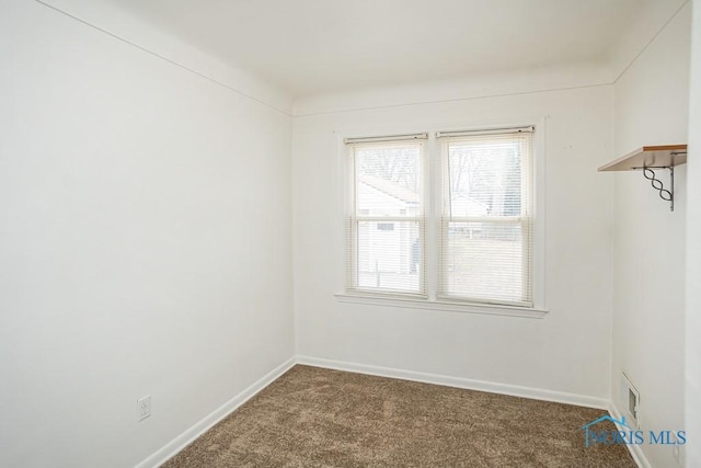 carpeted spare room featuring baseboards