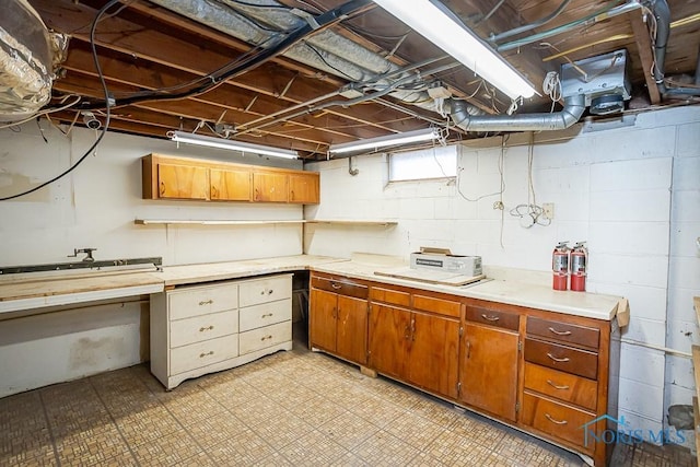 kitchen with brown cabinetry, light floors, and light countertops