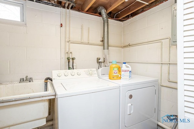 clothes washing area with washer and dryer, laundry area, and a sink