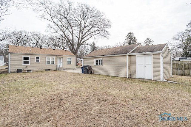 back of property with a yard, fence, an outbuilding, and entry steps