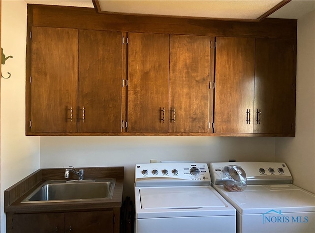 laundry room featuring cabinet space, washing machine and dryer, and a sink