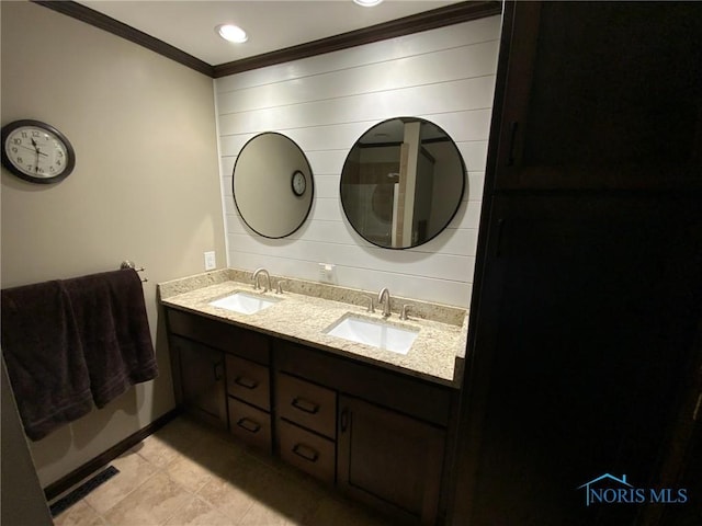 full bathroom featuring crown molding, tile patterned flooring, double vanity, and baseboards