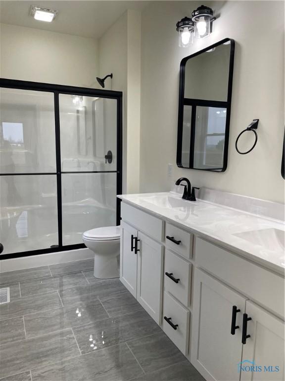 9641 Early Dr, Findlay, OH 45840 - bathroom with double vanity, a shower stall, toilet, and a sink