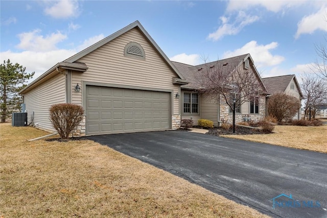 ranch-style house featuring a front lawn, aphalt driveway, stone siding, central AC, and an attached garage