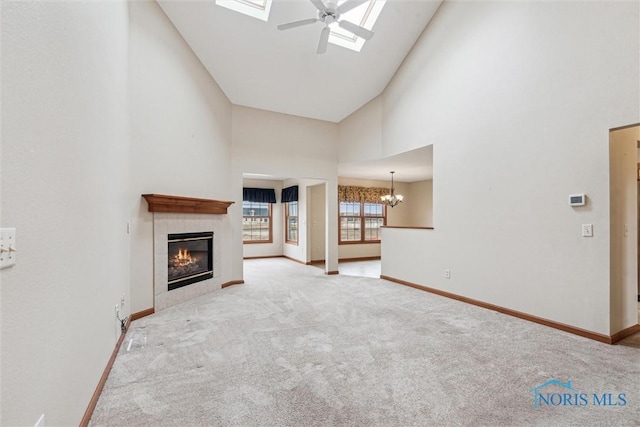 14540 Olde Trail Dr, Perrysburg, OH 43551 - unfurnished living room with baseboards, carpet floors, a fireplace, a skylight, and high vaulted ceiling