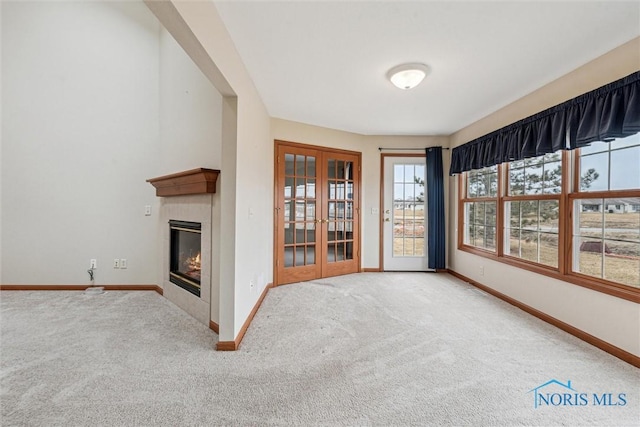 14540 Olde Trail Dr, Perrysburg, OH 43551 - unfurnished living room with baseboards, carpet floors, a glass covered fireplace, and french doors