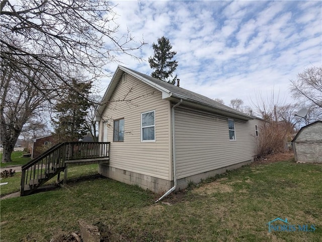 view of home's exterior featuring a lawn, stairs, and a wooden deck