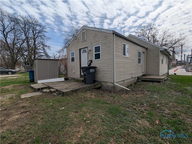 exterior space with a shed, a wooden deck, an outbuilding, and a yard