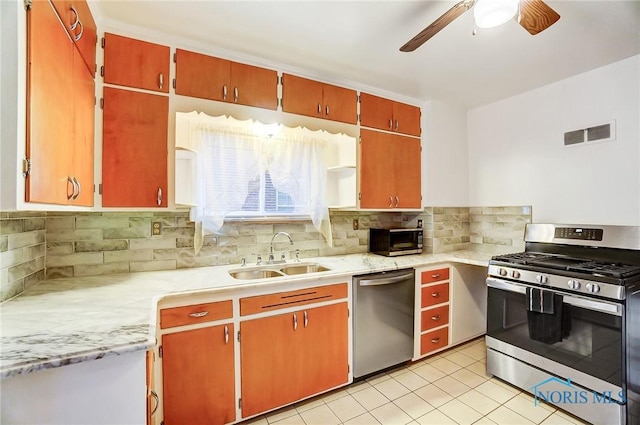 kitchen featuring backsplash, appliances with stainless steel finishes, light countertops, and a sink