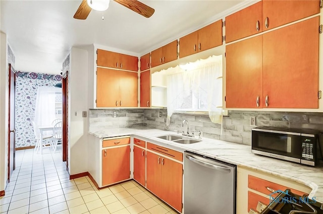 kitchen with dishwasher, light countertops, decorative backsplash, light tile patterned flooring, and a sink