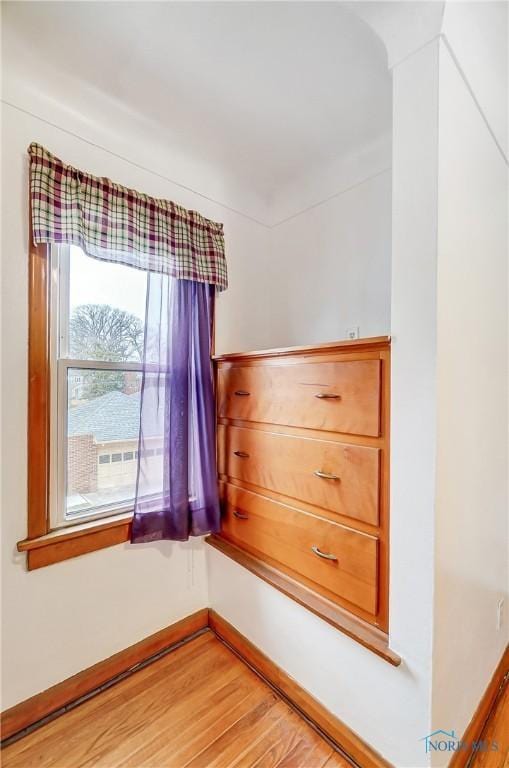 spare room featuring light wood-type flooring and baseboards