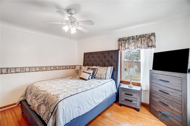 bedroom featuring light wood-style flooring, a ceiling fan, and baseboards