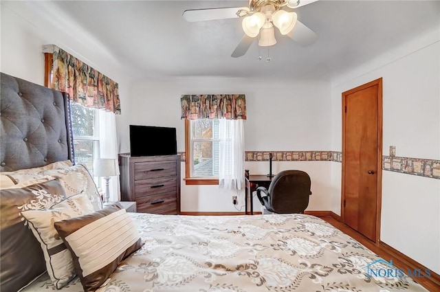 bedroom with wood finished floors, baseboards, and ceiling fan