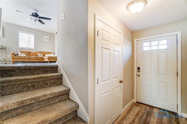 entrance foyer featuring stairs, wood finished floors, baseboards, and a wealth of natural light