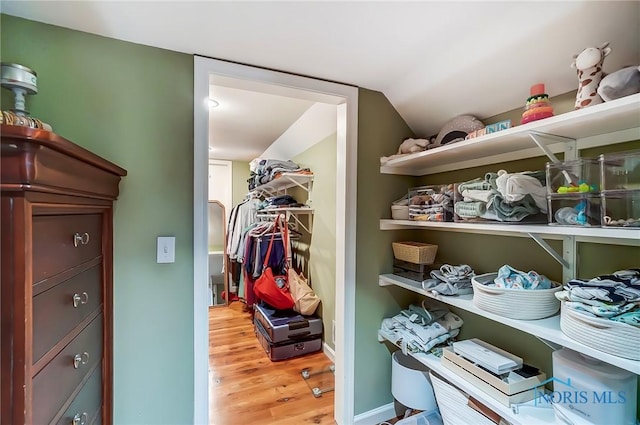 spacious closet featuring light wood-type flooring and lofted ceiling