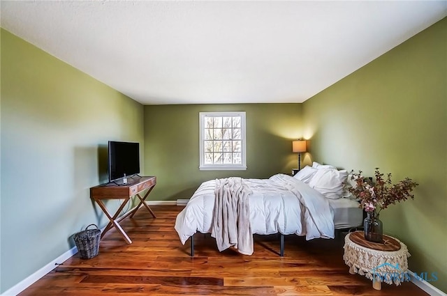 bedroom featuring wood finished floors and baseboards