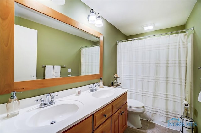 bathroom featuring double vanity, tile patterned floors, toilet, and a sink