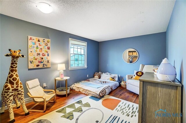 bedroom featuring a textured ceiling and wood finished floors