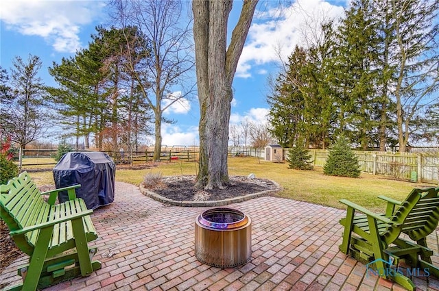 view of patio / terrace with a fenced backyard, area for grilling, a storage unit, and an outdoor structure