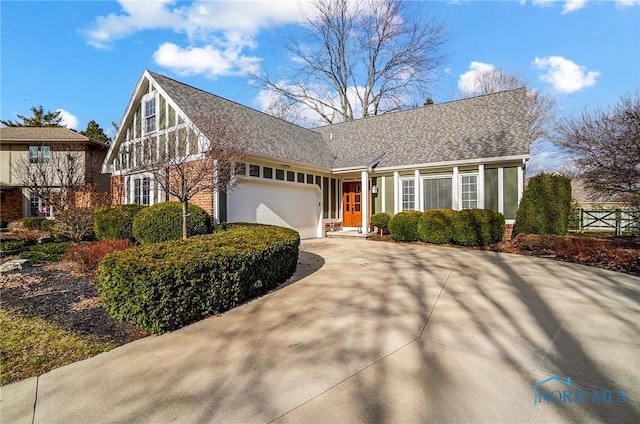 view of front facade featuring concrete driveway, brick siding, a garage, and roof with shingles