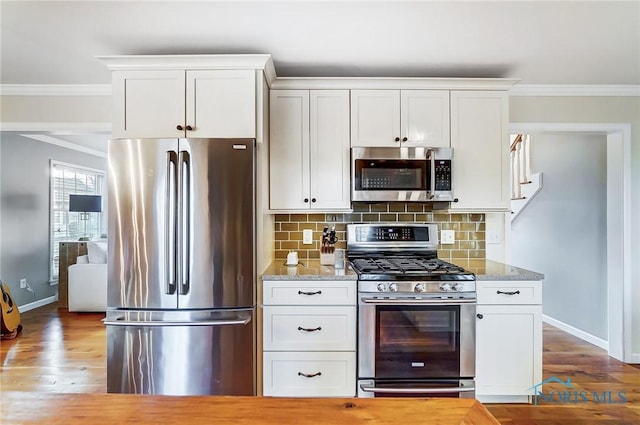 kitchen with tasteful backsplash, stainless steel appliances, and crown molding