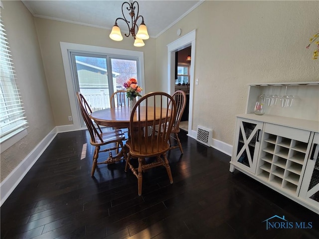 dining space with visible vents, ornamental molding, dark wood finished floors, baseboards, and a chandelier