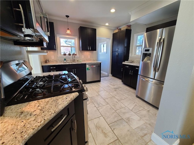 kitchen with ornamental molding, light stone countertops, appliances with stainless steel finishes, and a sink