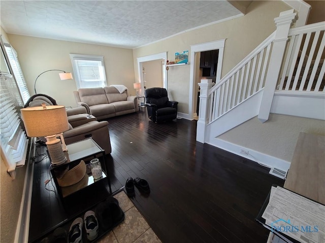 living room featuring stairway, wood finished floors, baseboards, ornamental molding, and a textured ceiling