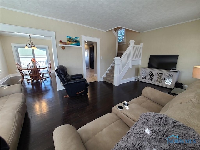 living area with stairs, wood finished floors, baseboards, and ornamental molding