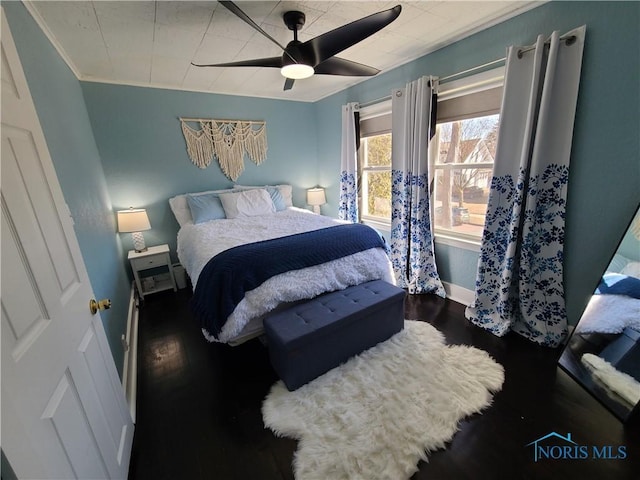 bedroom with wood finished floors, baseboards, and ceiling fan