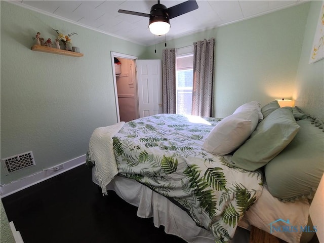 bedroom featuring baseboards, visible vents, ceiling fan, a closet, and crown molding