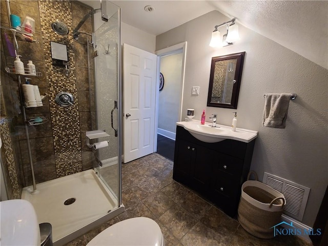 bathroom with visible vents, toilet, a shower stall, lofted ceiling, and vanity