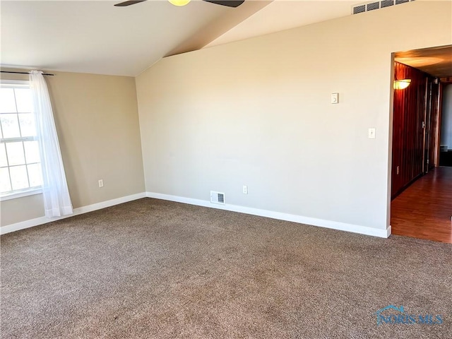 carpeted empty room featuring visible vents, baseboards, lofted ceiling, and ceiling fan