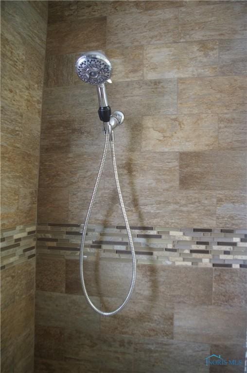 interior details featuring a tile shower