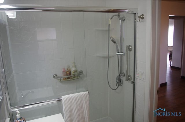 bathroom featuring a shower stall and wood finished floors