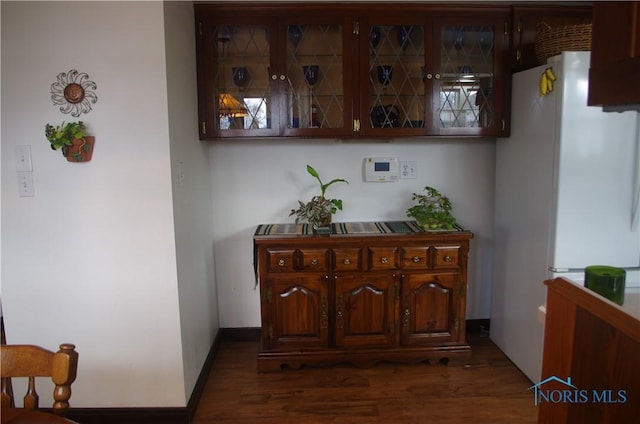 interior space featuring dark wood finished floors, baseboards, and freestanding refrigerator