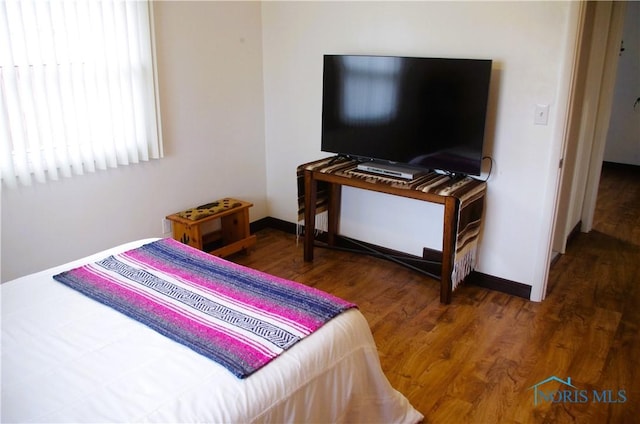 bedroom featuring baseboards and wood finished floors