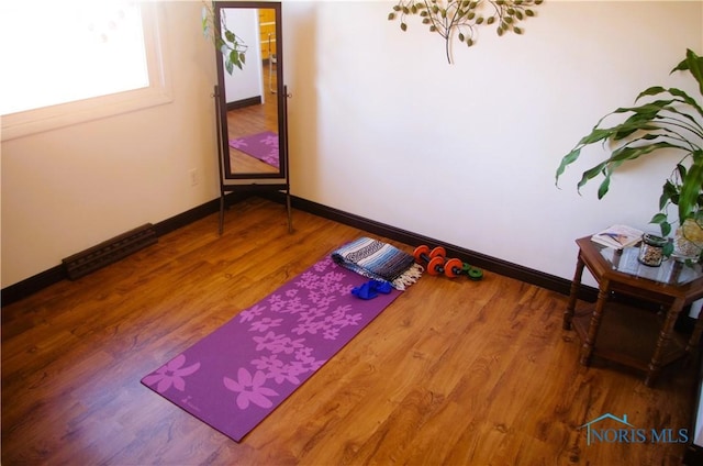 workout room featuring wood finished floors and baseboards