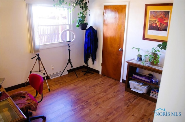 interior space featuring visible vents, baseboards, and wood finished floors