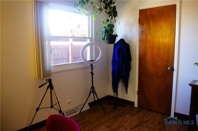 misc room with wood finished floors, visible vents, and baseboards