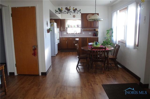 dining room featuring dark wood finished floors and baseboards