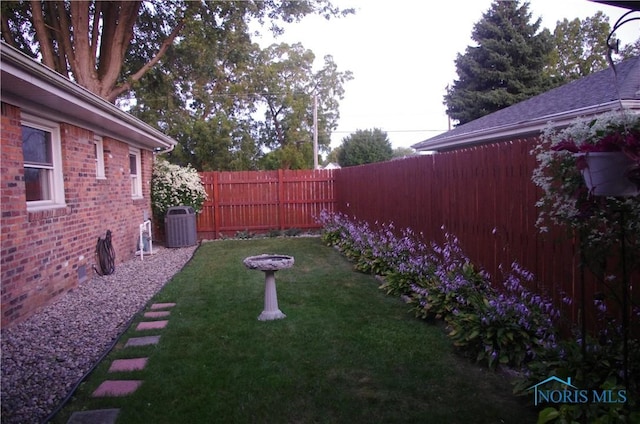 view of yard featuring central AC and a fenced backyard