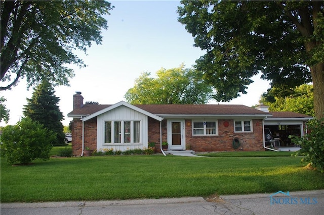 ranch-style home with brick siding, a chimney, and a front yard